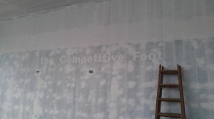 Faded The Competitive Foot verbiage on wall