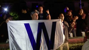 A fan at FitzGerald's unfurls the "W" banner signifying the Chicago Cubs' most significant win ever.